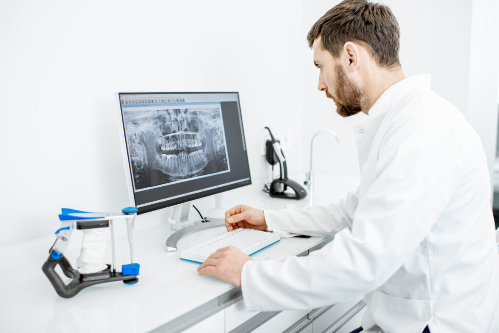 Dentist looking at xray on computer screen