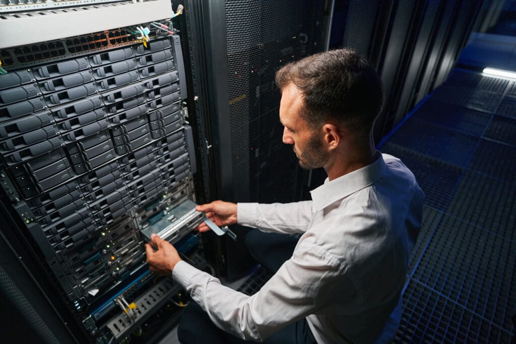 man working on cybersecurity solutions in a computer server room