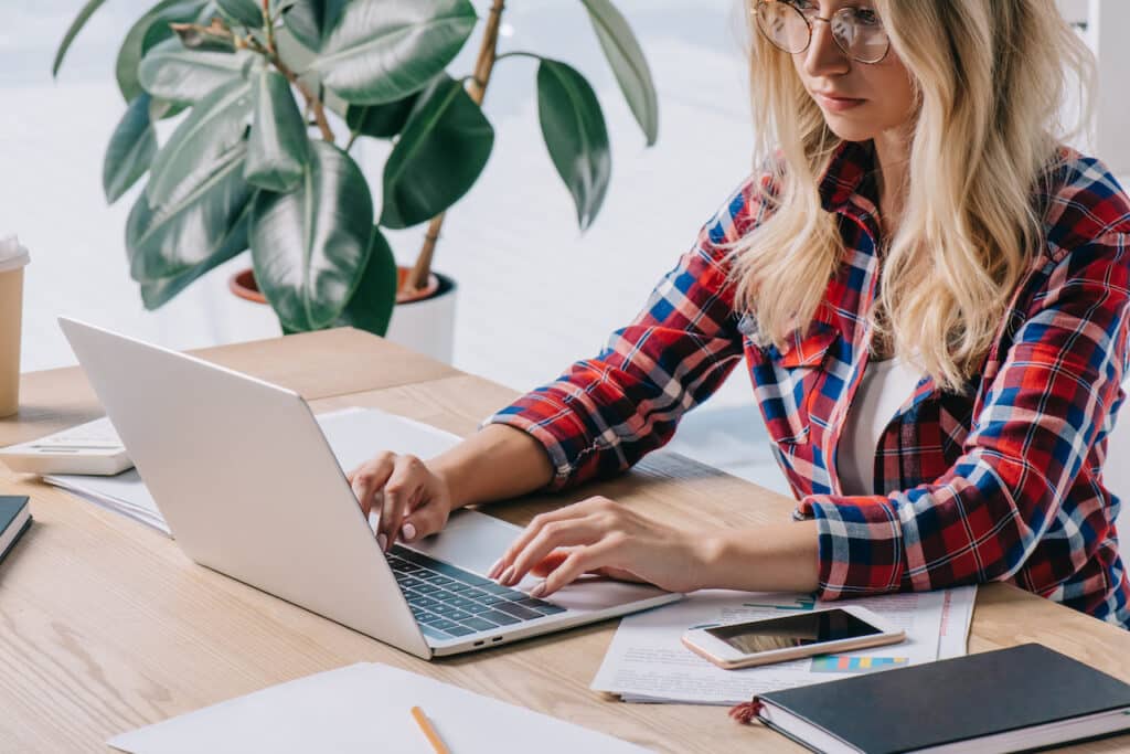 businesswoman using laptop at workplace working to avoid cyber attacks