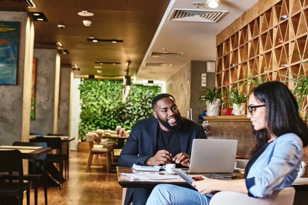 man and woman sitting at a table discussing plans for disaster recovery for their company