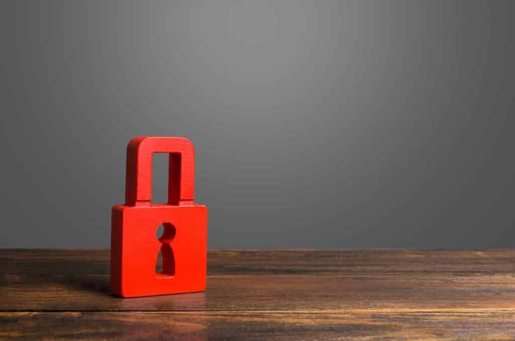 Image of red padlock on top of a table symbolizing protection