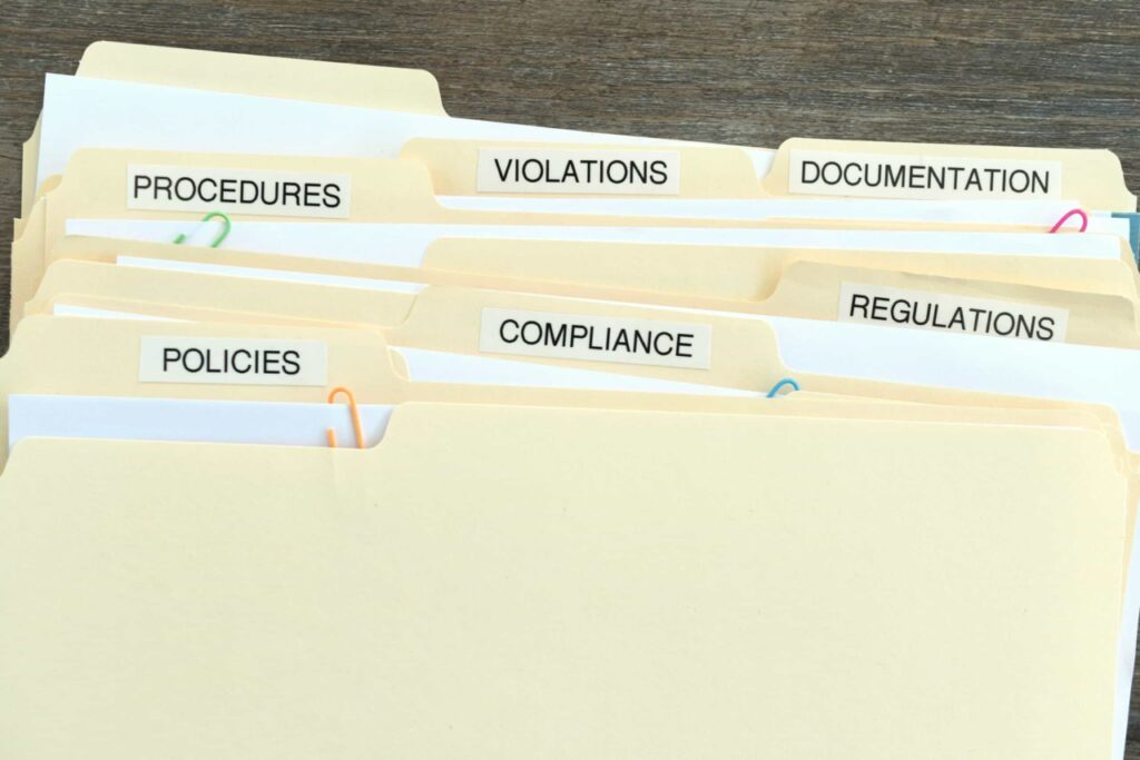 stack of folders including HIPAA compliance requirements