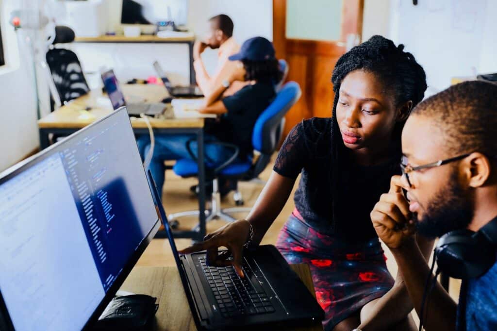 Two people look at a computer screen together